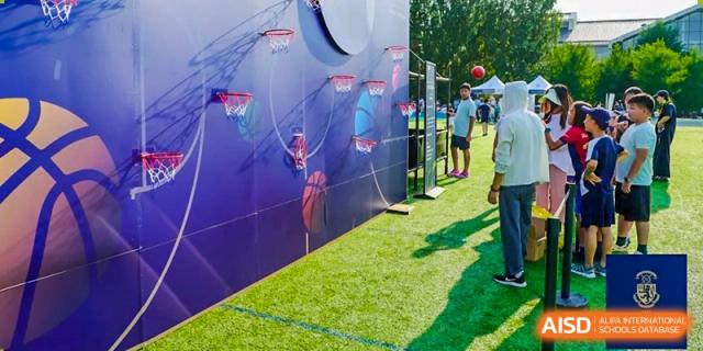 Multiple basketball hoops are set up on an outdoor field for a Harrow International School Beijing (AISL Beijing) sports activity.