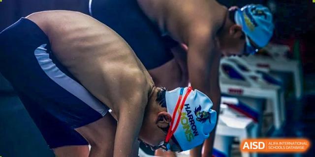 A student from Harrow International School Beijing (AISL Beijing), wearing a swim cap, is preparing to start a swimming race.