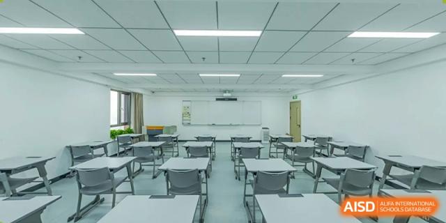 An empty, neat, and brightly lit modern classroom with grey tables and chairs at BEIJING CHAOYANG TONGWEN FOREIGN LANGUAGE SCHOOL.