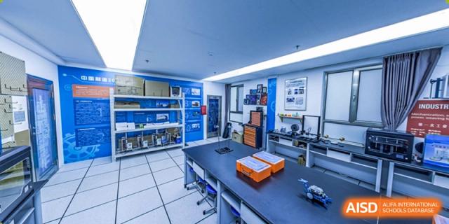 A Robotics or STEM lab at BEIJING CHAOYANG TONGWEN FOREIGN LANGUAGE SCHOOL with worktables, blue shelving, and electronic equipment.