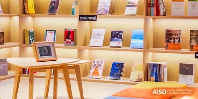A simple wooden shelf displaying various books and educational materials in the library at BEIJING CHAOYANG TONGWEN FOREIGN LANGUAGE SCHOOL.