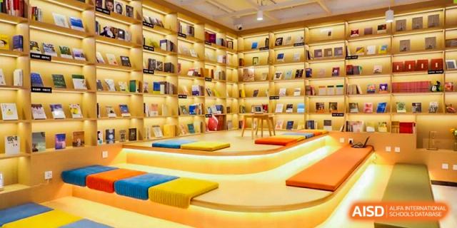 A curved, multi-level reading area with colorful seating and full bookshelves in the school's library at BEIJING CHAOYANG TONGWEN FOREIGN LANGUAGE SCHOOL.