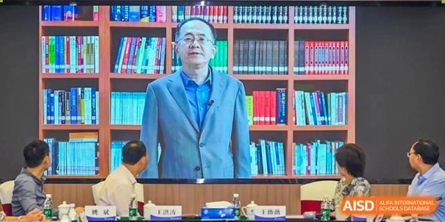 A professional speaker or educator addressing an audience with a wall of books visible behind them at BEIJING CHAOYANG TONGWEN FOREIGN LANGUAGE SCHOOL.