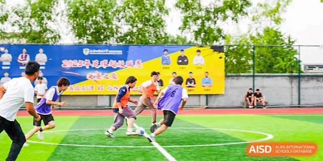 Students actively playing soccer during an intense game on a green turf field at BEIJING CHAOYANG TONGWEN FOREIGN LANGUAGE SCHOOL.