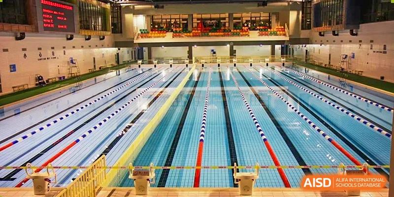 The bright, modern lanes and interior of the indoor swimming pool facility at BEIJING CHAOYANG TONGWEN FOREIGN LANGUAGE SCHOOL.