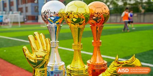 A close-up of several gold and silver soccer-themed trophies and awards for school competitions at BEIJING CHAOYANG TONGWEN FOREIGN LANGUAGE SCHOOL.