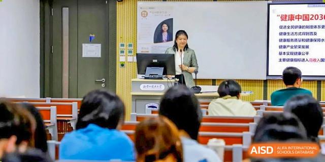 A photo showing a teacher standing in front of students and teaching them in the classroom, at Beijing Foreign Studies University International Curriculum Center.