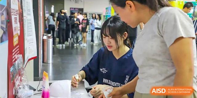 A photo showing a female student performing a scientific experiment, at Beijing Foreign Studies University International Curriculum Center.
