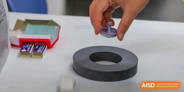 A photo showing a hand holding a magnetic object, at Beijing Foreign Studies University International Curriculum Center.