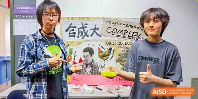 A photo showing a group of male students posing for a photo with a poster in the background, at Beijing Foreign Studies University International Curriculum Center.