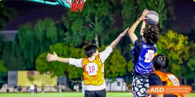 An image showing students playing basketball, at Beijing Foreign Studies University International Curriculum Center.