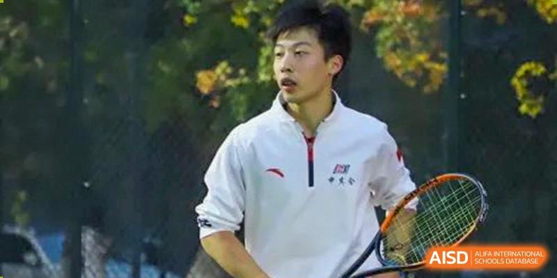 An image showing a young man with a tennis racket, at Beijing Foreign Studies University International Curriculum Center.