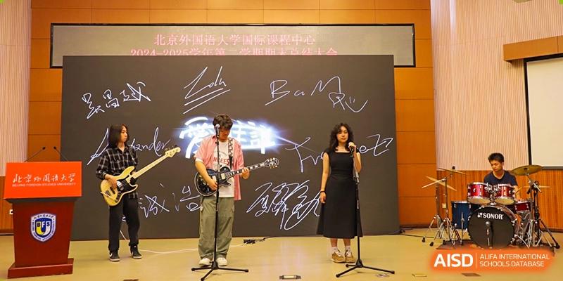 A photo showing a musical band performing on a stage, with a female singer, at Beijing Foreign Studies University International Curriculum Center.