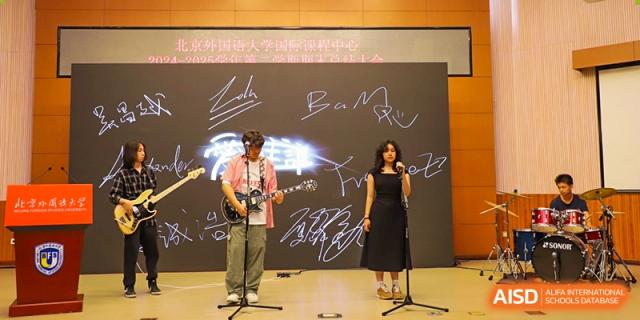 A photo showing a musical band performing on a stage, with a female singer, at Beijing Foreign Studies University International Curriculum Center.