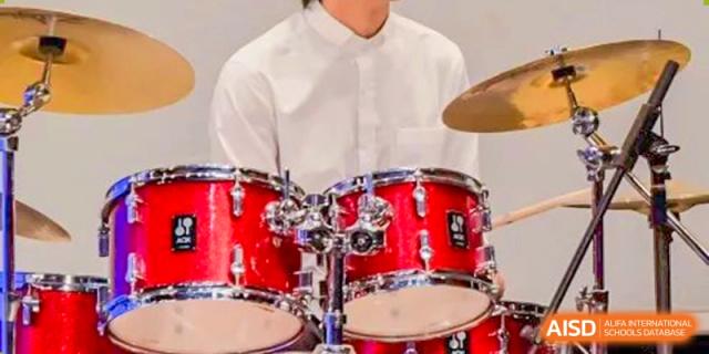 A photo showing a musical drum kit on a stage, at Beijing Foreign Studies University International Curriculum Center.