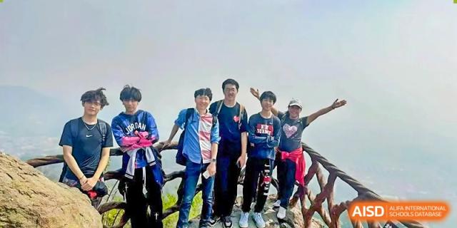 A photo showing a group of students posing in front of their bikes for a photo, at Beijing Foreign Studies University International Curriculum Center.