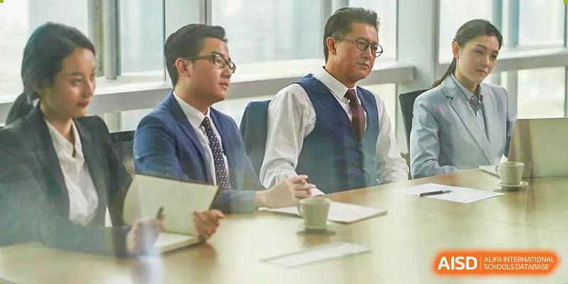 A photo showing two men in formal dresses having a discussion, at Beijing Foreign Studies University International Curriculum Center.