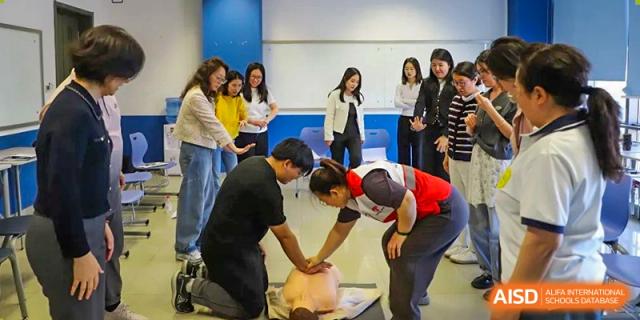 A photo showing a group of students getting a lesson on health and nutrition from a teacher, at Beijing Foreign Studies University International Curriculum Center.
