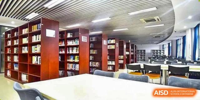 Students from Shijingshan School of The High School Affiliated to Renmin University of China gather around a teacher and a book.