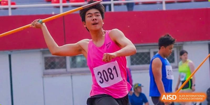 A male student from Shijingshan School of The High School Affiliated to Renmin University of China, wearing a pink shirt, participates in a javelin throw.