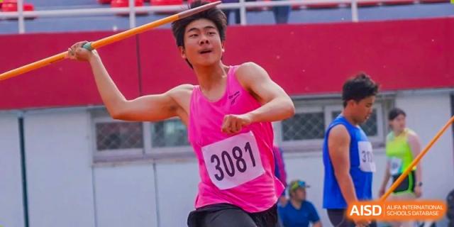 A male student from Shijingshan School of The High School Affiliated to Renmin University of China, wearing a pink shirt, participates in a javelin throw.