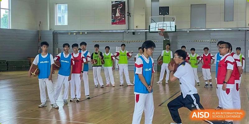 A group of students from Shijingshan School of The High School Affiliated to Renmin University of China in a gym performs a choreographed routine.