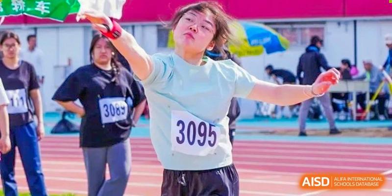A female student from Shijingshan School of The High School Affiliated to Renmin University of China, wearing a light blue shirt, competes in a discus or shot put event.