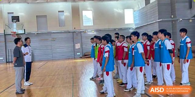Students from Shijingshan School of The High School Affiliated to Renmin University of China in white tracksuits stand in a line on a track.
