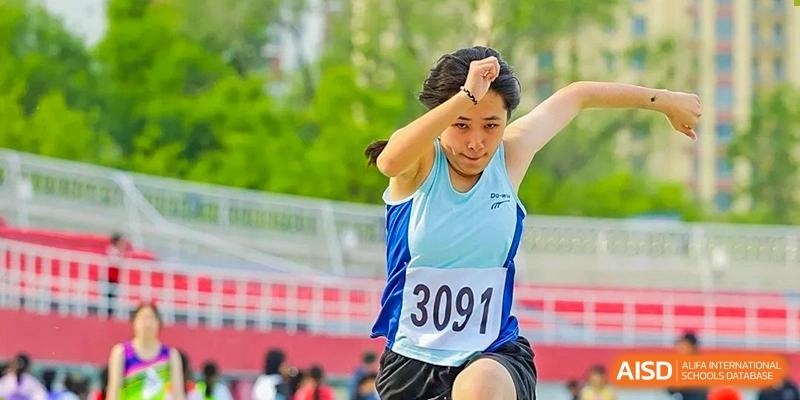 A female student from Shijingshan School of The High School Affiliated to Renmin University of China, wearing a light blue shirt, competes in a discus or shot put event.