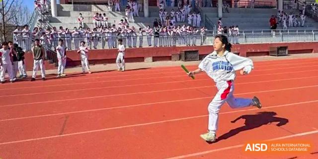 A male student from Shijingshan School of The High School Affiliated to Renmin University of China pitches a baseball.