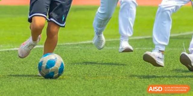 Students from Shijingshan School of The High School Affiliated to Renmin University of China play soccer, focusing on a ball.