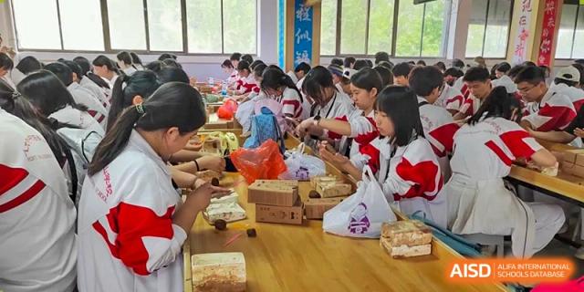 Students from Shijingshan School of The High School Affiliated to Renmin University of China sit at a table and eat lunch.