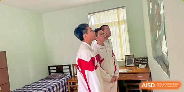 Two students from Shijingshan School of The High School Affiliated to Renmin University of China, one wearing a traditional outfit, stand in a room.