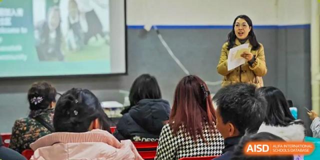 Rear view of students and parents watching a presentation on a large screen in a classroom. Beanstalk International Bilingual School (BIBS) - Chengdu