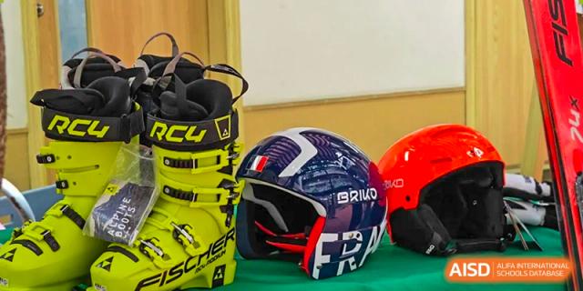 Professional ski gear including a yellow Fischer boot and a Briko helmet displayed on a green surface. Beanstalk International Bilingual School (BIBS) - Chengdu