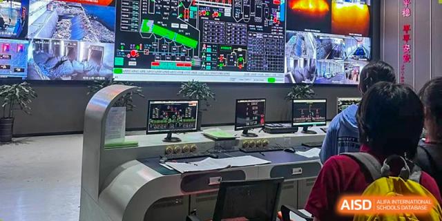 A modern control room featuring large digital monitoring screens and multiple desktop workstations. Beanstalk International Bilingual School (BIBS) - Chengdu