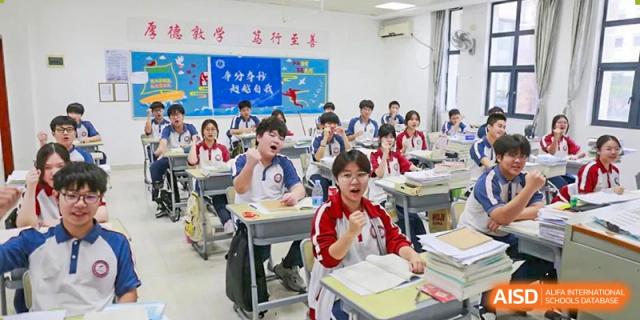 Engaged students in red and white uniforms participating actively in a class at The Experimental School Affiliated with Zhuhai No.1 High School.