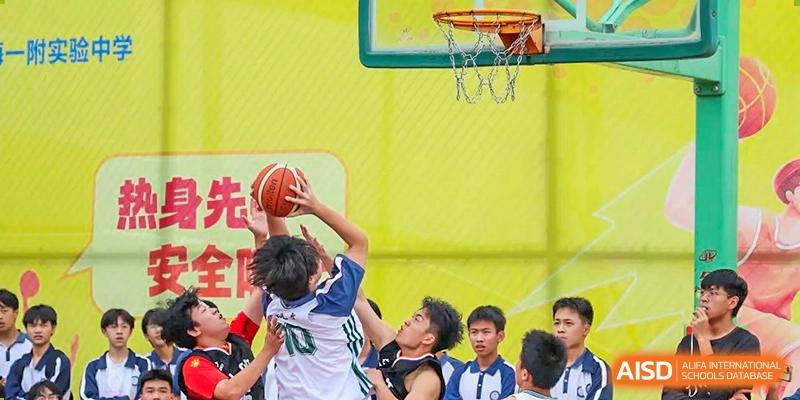 A student from The Experimental School Affiliated with Zhuhai No.1 High School in a black and white uniform attempting a layup during a basketball game.