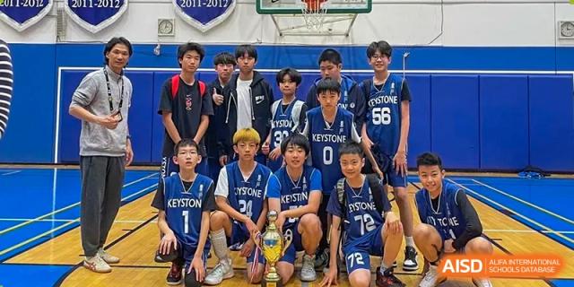 Beijing Keystone Academy boys basketball team poses with their trophy after a game.