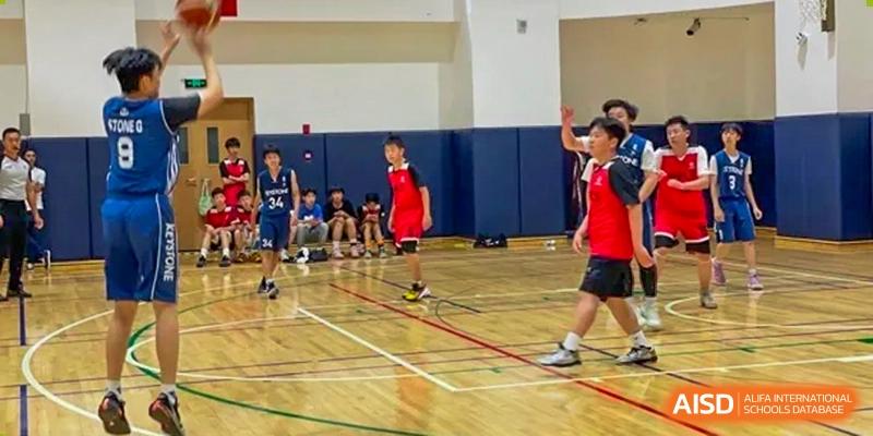 A Beijing Keystone Academy basketball game in progress on the court.