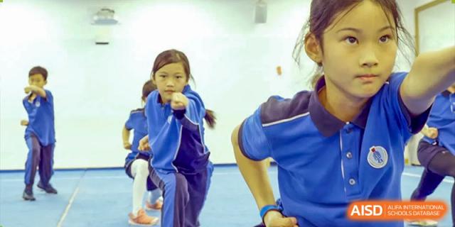 A close-up shot of young Beijing Keystone Academy students participating in a dance or movement class.