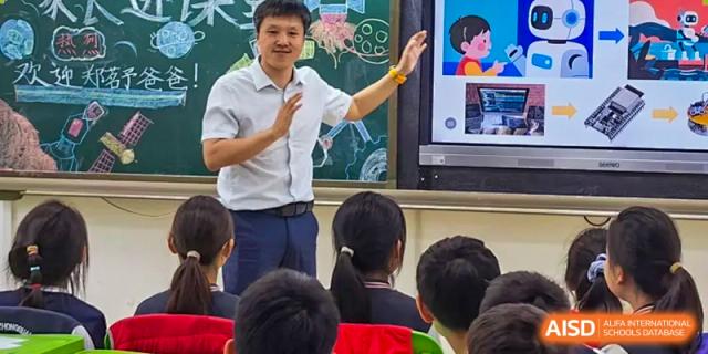 A Beijing Zhongguancun Foreign Language School teacher giving a presentation to a class with a large interactive screen.