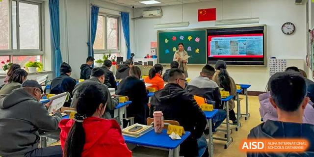 A Beijing Zhongguancun Foreign Language School teacher giving a lecture to a classroom full of students.