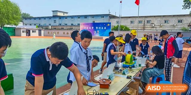 Beijing Zhongguancun Foreign Language School students and a teacher working together on a project at a table.