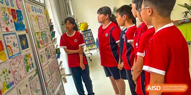 Beijing Zhongguancun Foreign Language School students looking at a display on a wall.