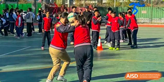 A photo showing two students playing an outdoor game, at Beijing Zhongguancun Foreign Language School.