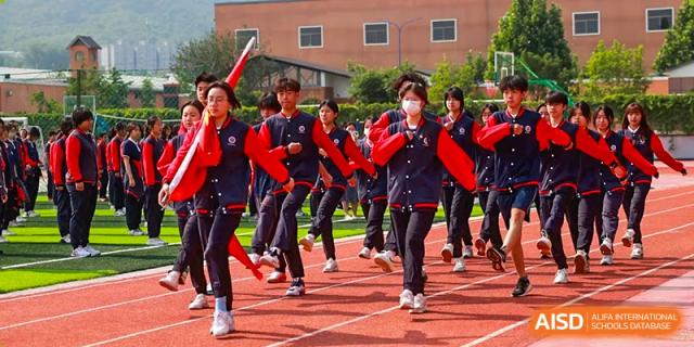 A photo showing a group of students participating in a running race, at Beijing Zhongguancun Foreign Language School.