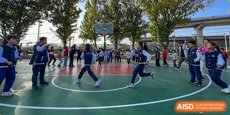 A photo showing students playing an outdoor game on a basketball court, at Beijing Zhongguancun Foreign Language School.
