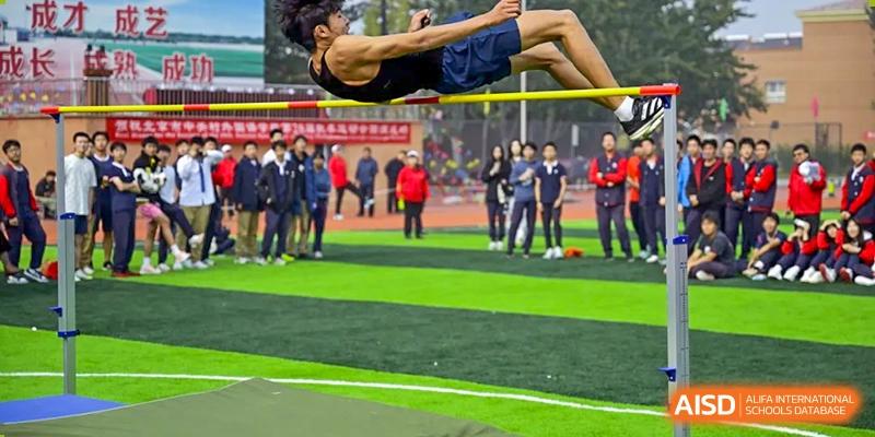 A photo showing a male student doing a high jump, at Beijing Zhongguancun Foreign Language School.
