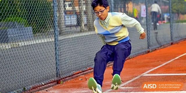 A photo showing a student doing a long jump, at Beijing Zhongguancun Foreign Language School.